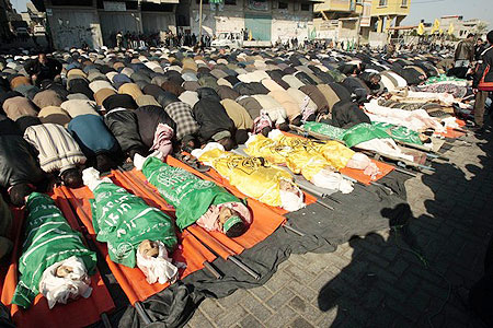 Mourners pray beside bodies of Palestinians, killed at a U.N. school, during their funeral in Jabalya in the northern Gaza Strip January 7, 2009.